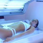 Attractive woman tanning at solarium