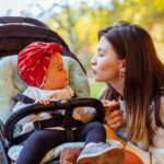 Mother looking with love at baby in stroller