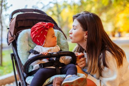 Mother looking with love at baby in stroller