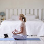 Woman With Digital Tablet Using Meditation App In Bedroom