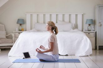 Woman With Digital Tablet Using Meditation App In Bedroom